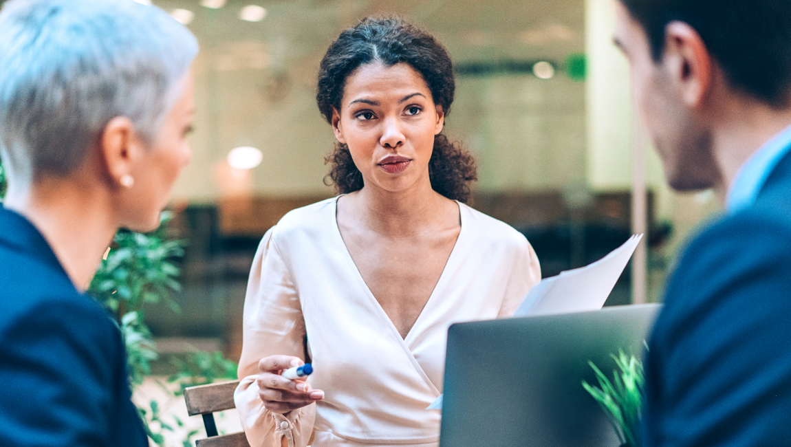 Three colleagues meeting outside on a park bench