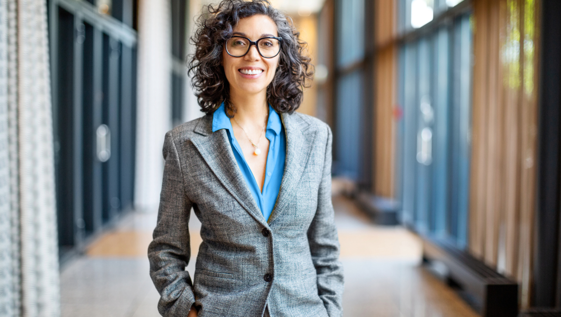 Smiling businesswoman wearing grey blazer and glasses