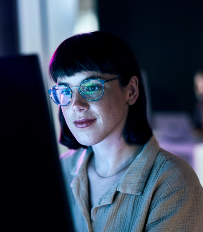 Young businesswoman working on desktop computer at night